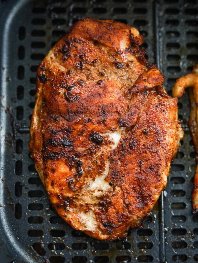 A cooked chicken breast inside of an air fryer.