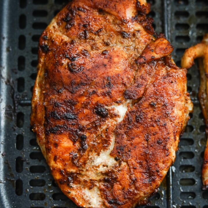 A cooked chicken breast inside of an air fryer.