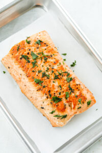 Cooked salmon topped with fresh chopped parsley.