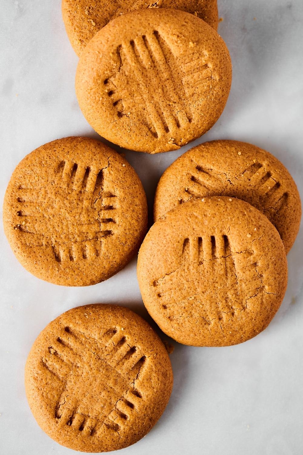 A bunch of peanut butter cookies on a white counter.