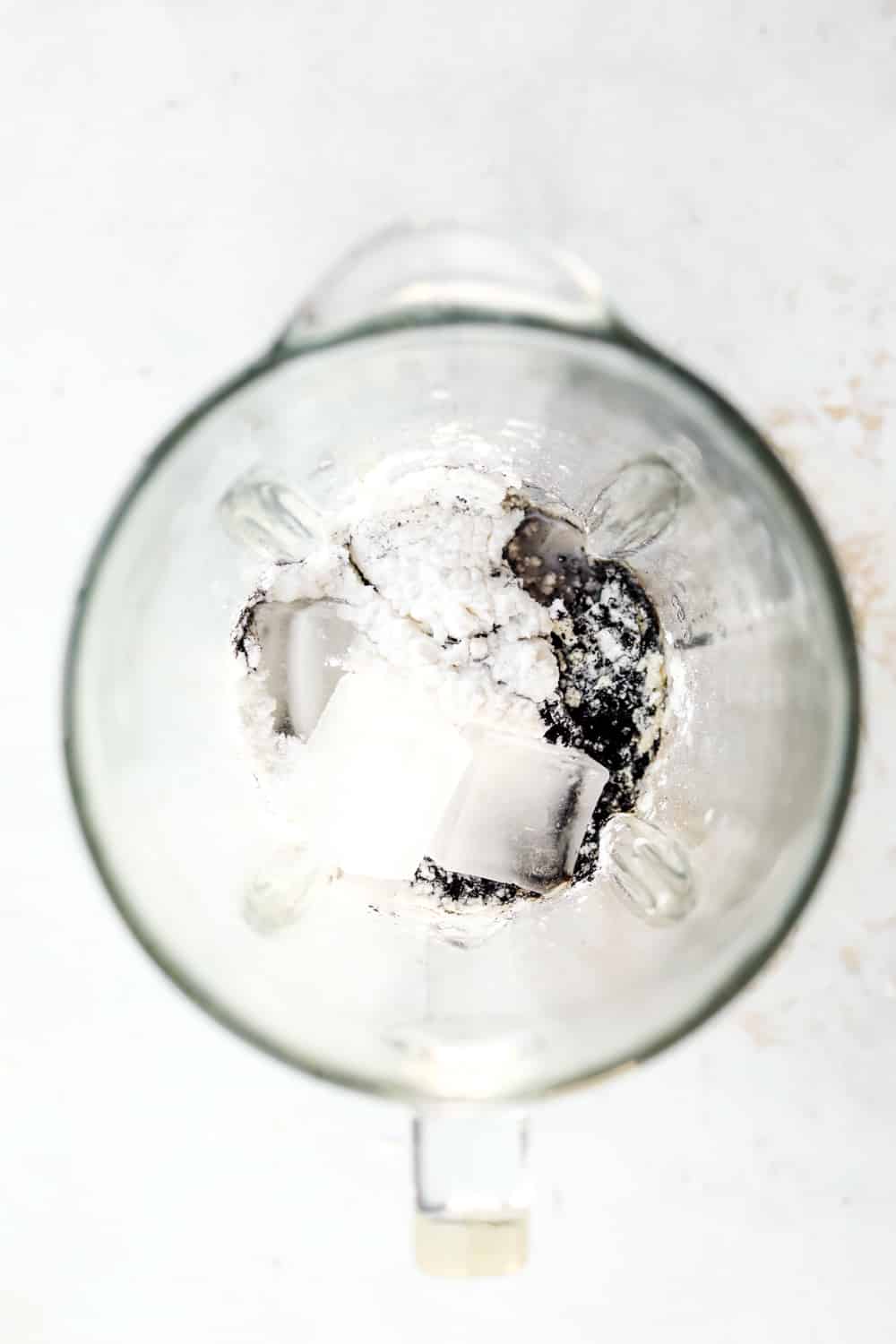 Ice, black cocoa powder, protein powder, and sweetener in a blender.