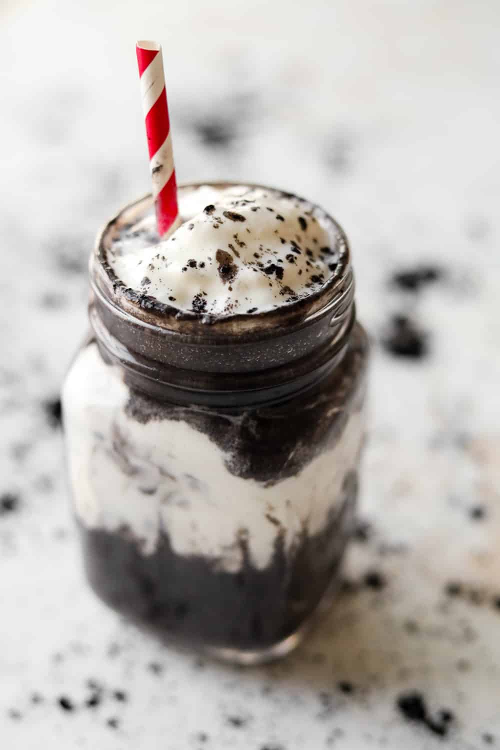 An Oreo protein shake in a glass mug.