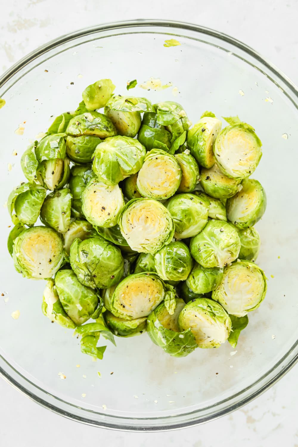 A bowl full of seasoned halved brussels sprouts.