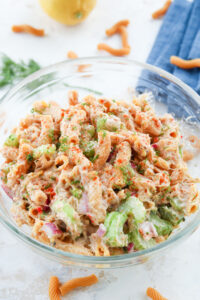 A clear glass bowl filled with tuna pasta salad.