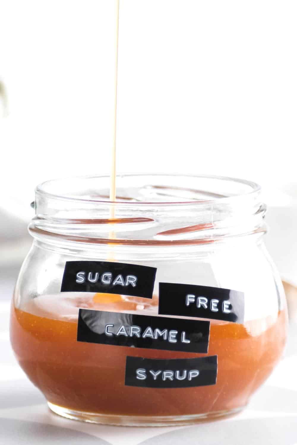 Caramel drizzling into a glass jar that has the caramel in it.