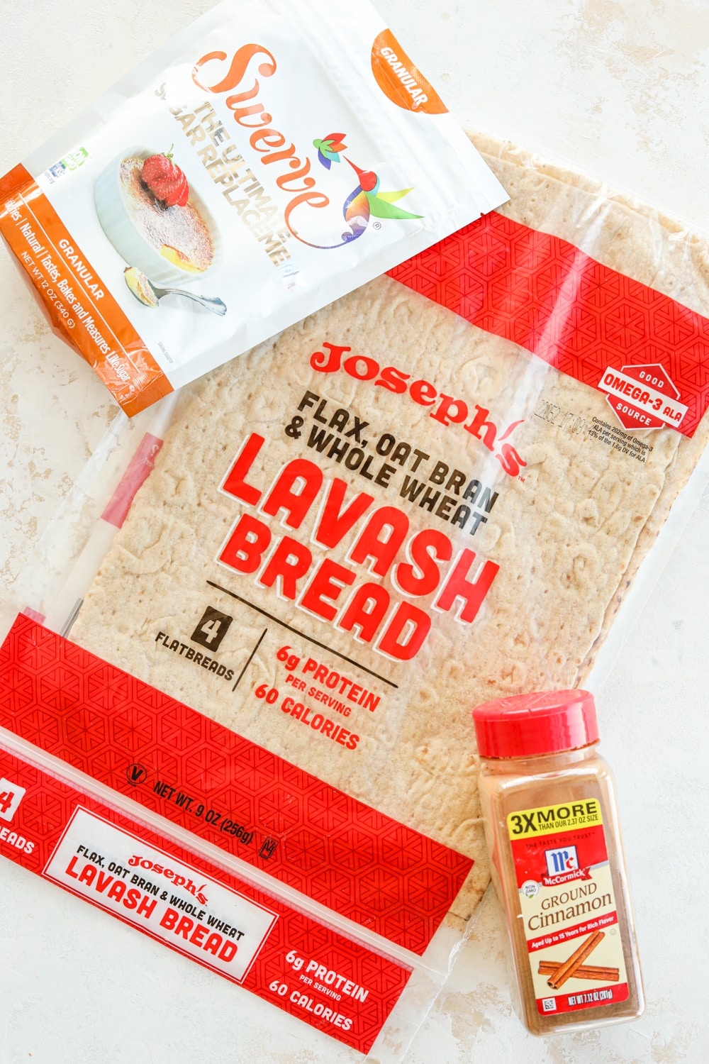 Sugar substitute, lavash bread, and ground cinnamon on a white table.