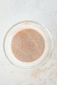 A cinnamon "sugar" topping that's been mixed together in a glass bowl.