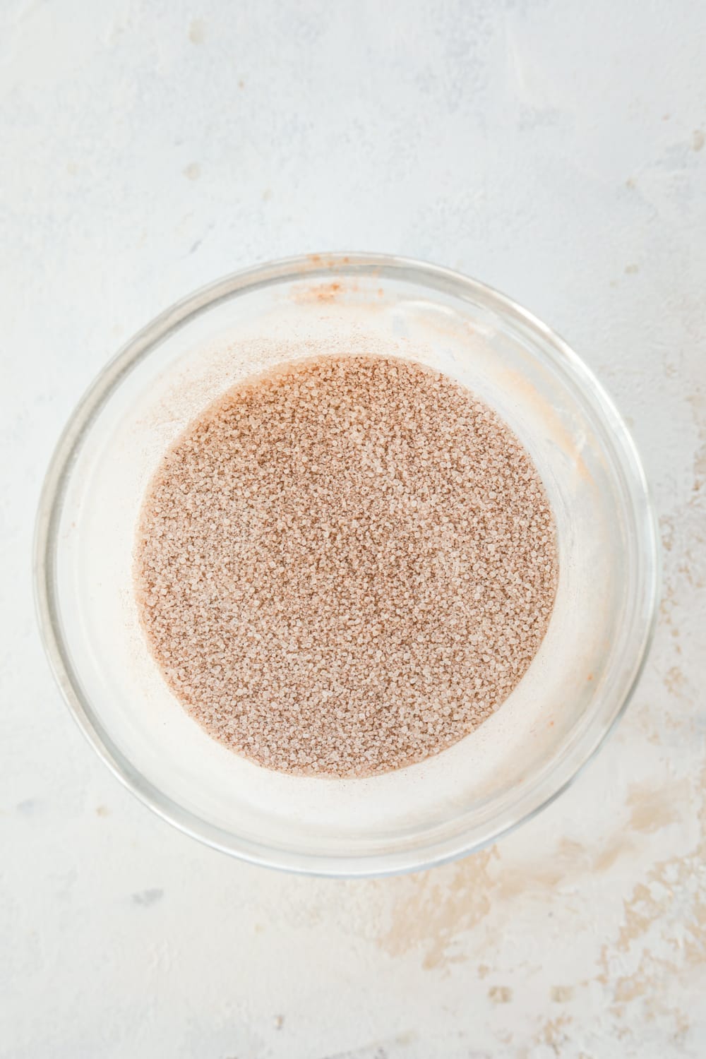 A cinnamon "sugar" topping that's been mixed together in a glass bowl.