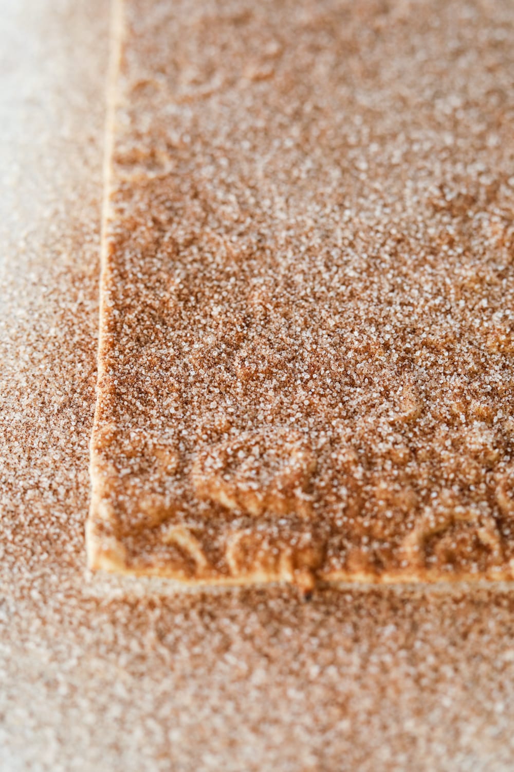 The bottom corner of a lavash bread. The bread is covered in a cinnamon "sugar" topping.