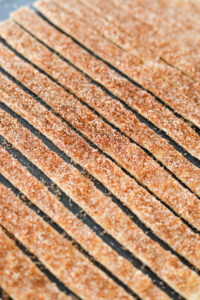 Quarter inch wide strips of lavash bread that has been cut into rows. There is a cinnamon "sugar" topping that has been added to the bread.