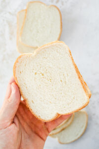 A hand holding two slices of low calorie bread.