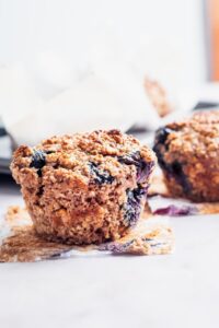 A blueberry protein muffin on a counter.
