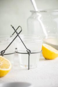 A glass of chick fil a lemonade in a wire holder.
