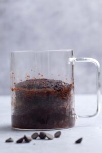 A chocolate protein mug cake in a glass mug.