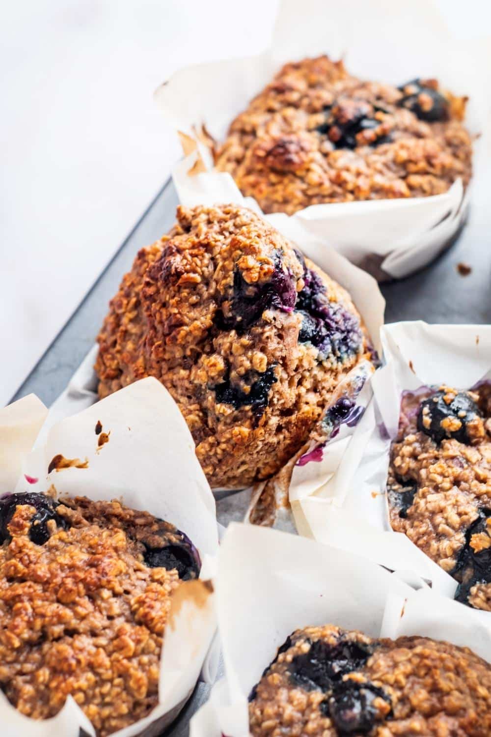 A few blueberry muffins in a muffin tin.