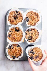 Baked blueberry protein muffins in a muffin tin.