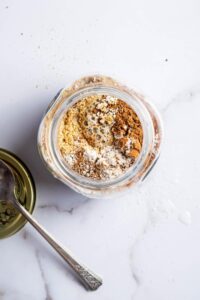 Cinnamon, flaxseed, Chia seeds, almond milk, almond flour, coconut flour, and confectioner erythritol all in a glass jar.