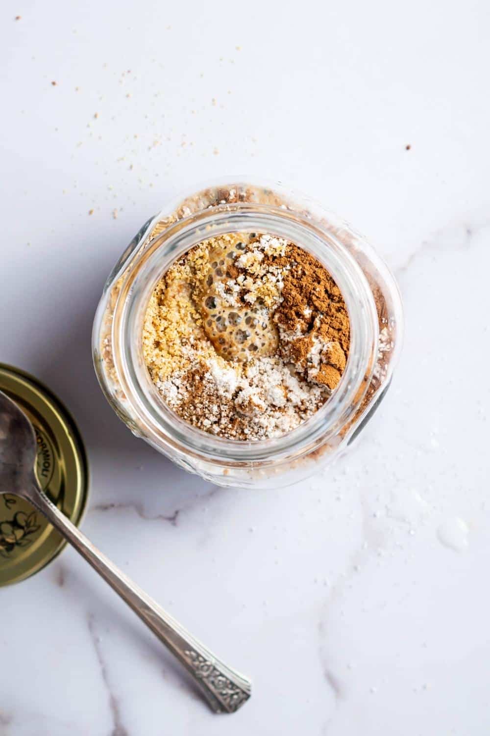 Cinnamon, flaxseed, Chia seeds, almond milk, almond flour, coconut flour, and confectioner erythritol all in a glass jar.