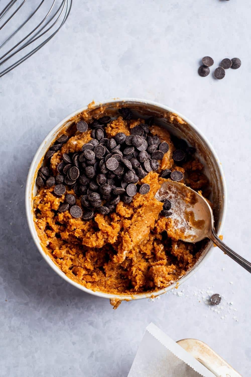 Chocolate chips on top of protein cookie dough in a bowl.