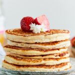 A stack of six protein pancakes on a glass plate.