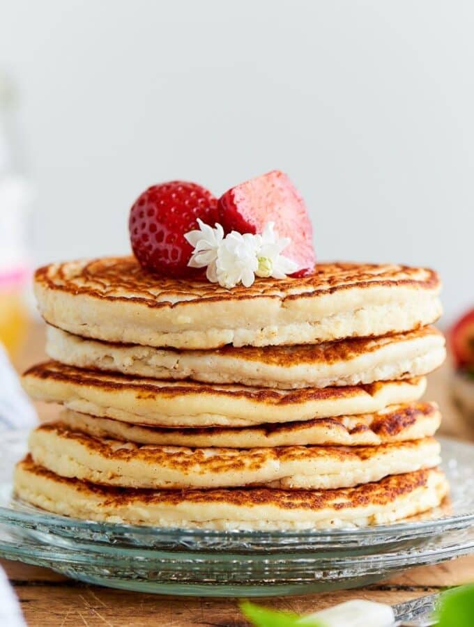 A stack of six protein pancakes on a glass plate.