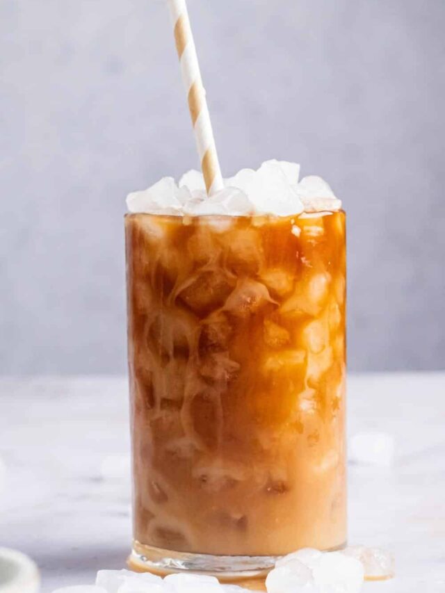 Protein coffee and ice cubes in a glass with a straw in it.