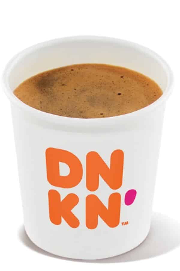 A small white cup of dunkin donuts espresso.