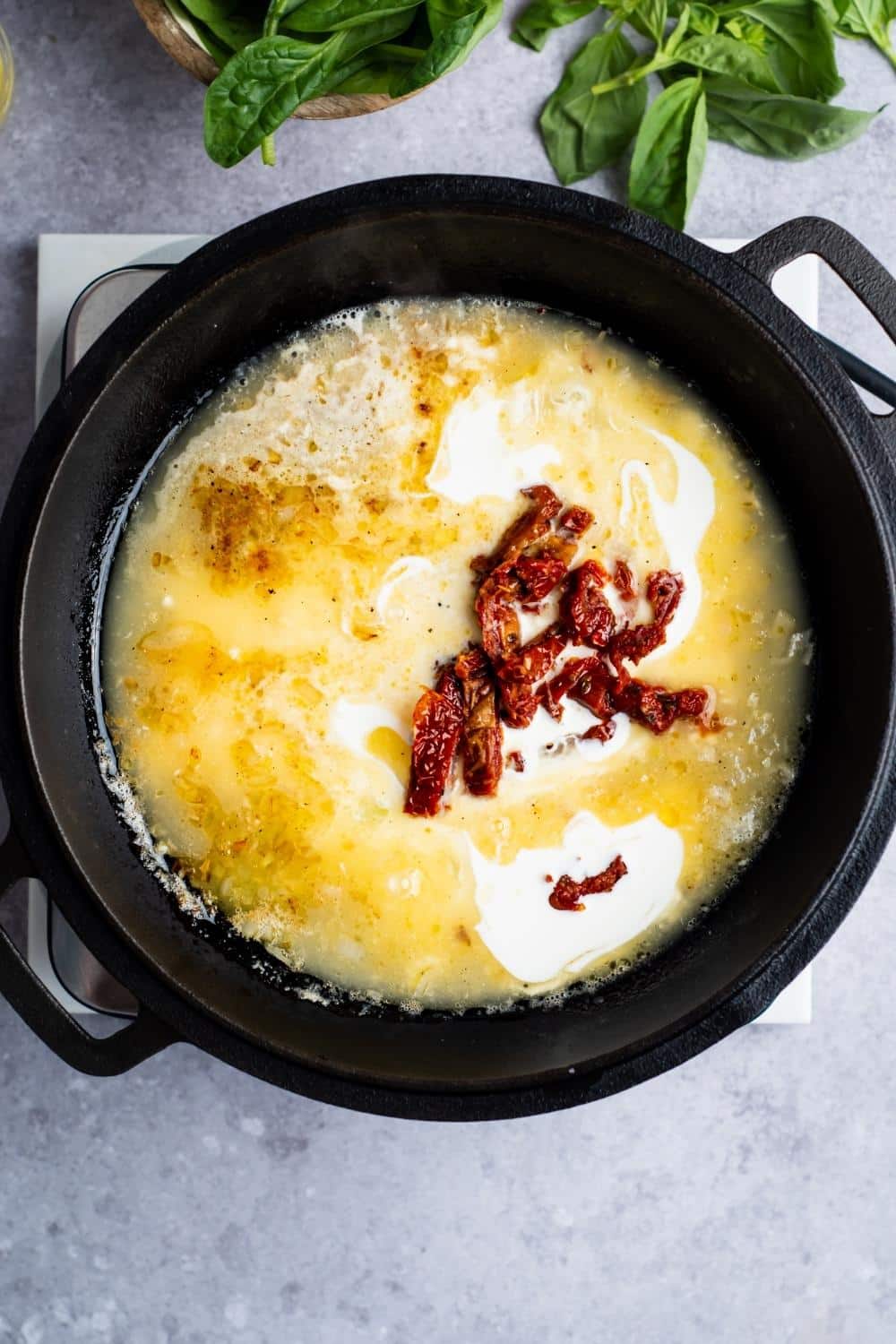 Sun dried tomatoes and heavy cream in a pot.