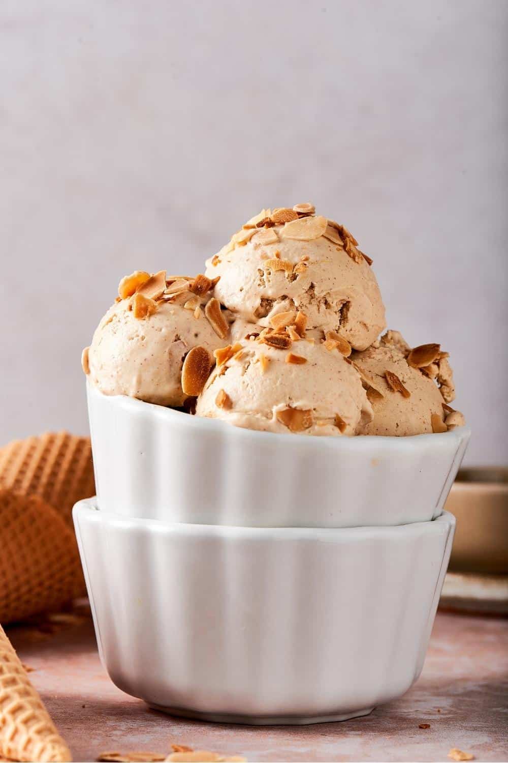 A bunch of toasted almond ice cream in a white bowl.