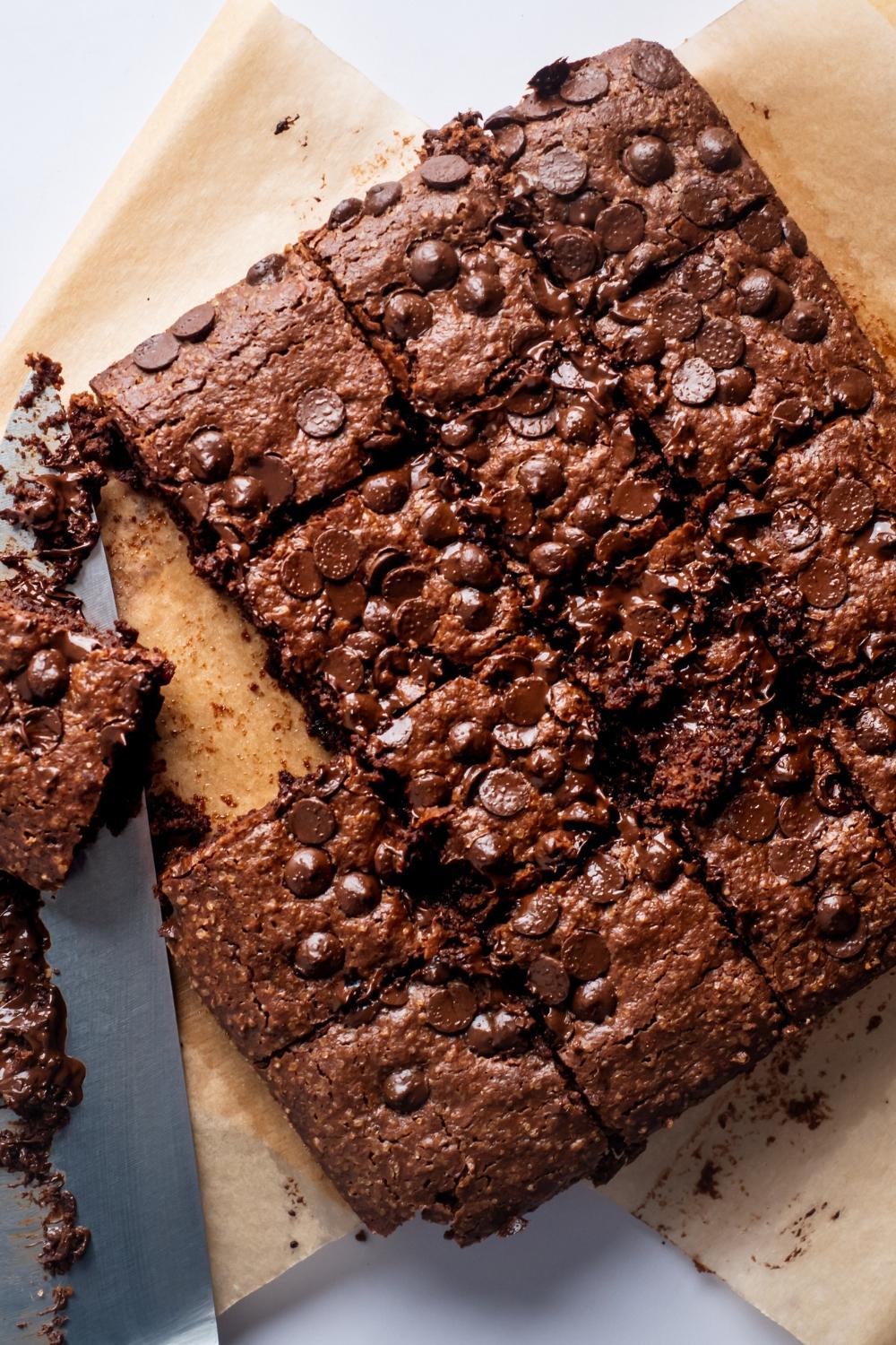 A square of cut brownies on a piece of parchment paper.