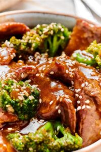 Broccoli and beef with stir fry sauce on it in a bowl.