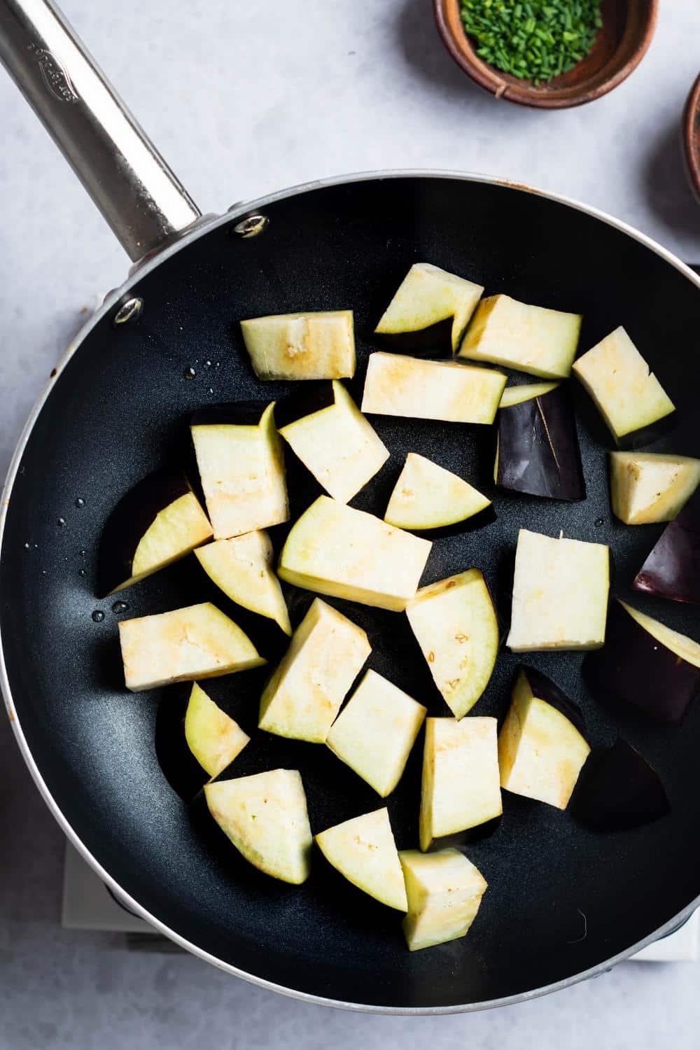 A bunch of eggplant squares in a skillet.