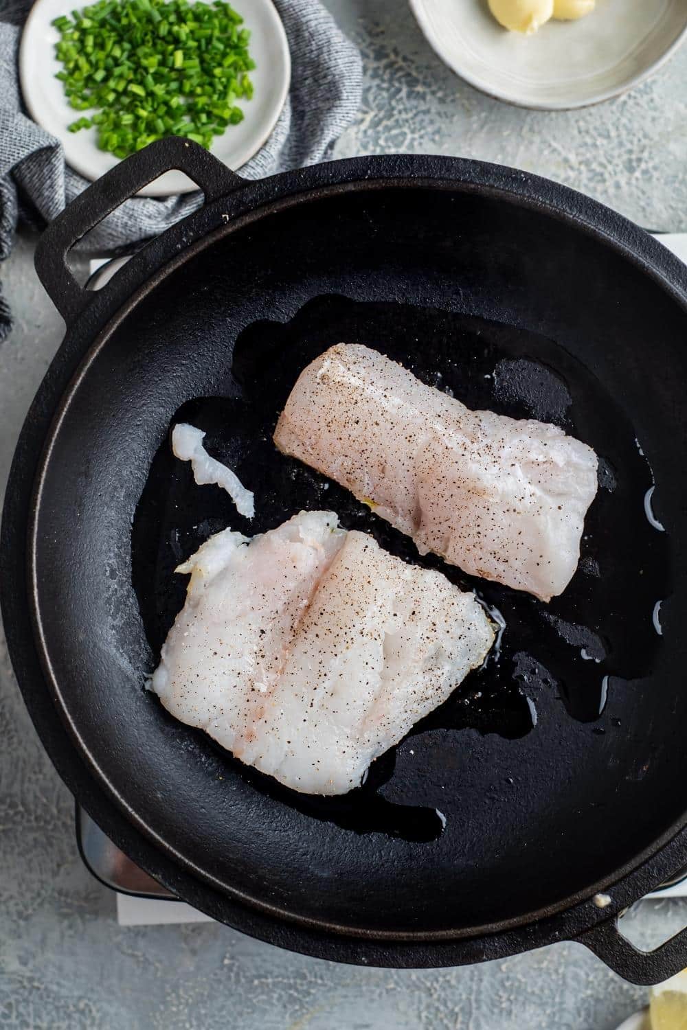 Two mahi mahi fillets in a skillet.