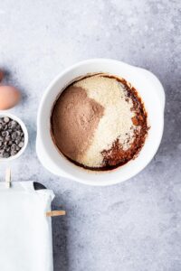 A bowl of cocoa powder, almond flour, chocolate protein powder in a bowl.