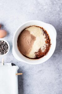 A bowl of cocoa powder, almond flour, chocolate protein powder in a bowl.