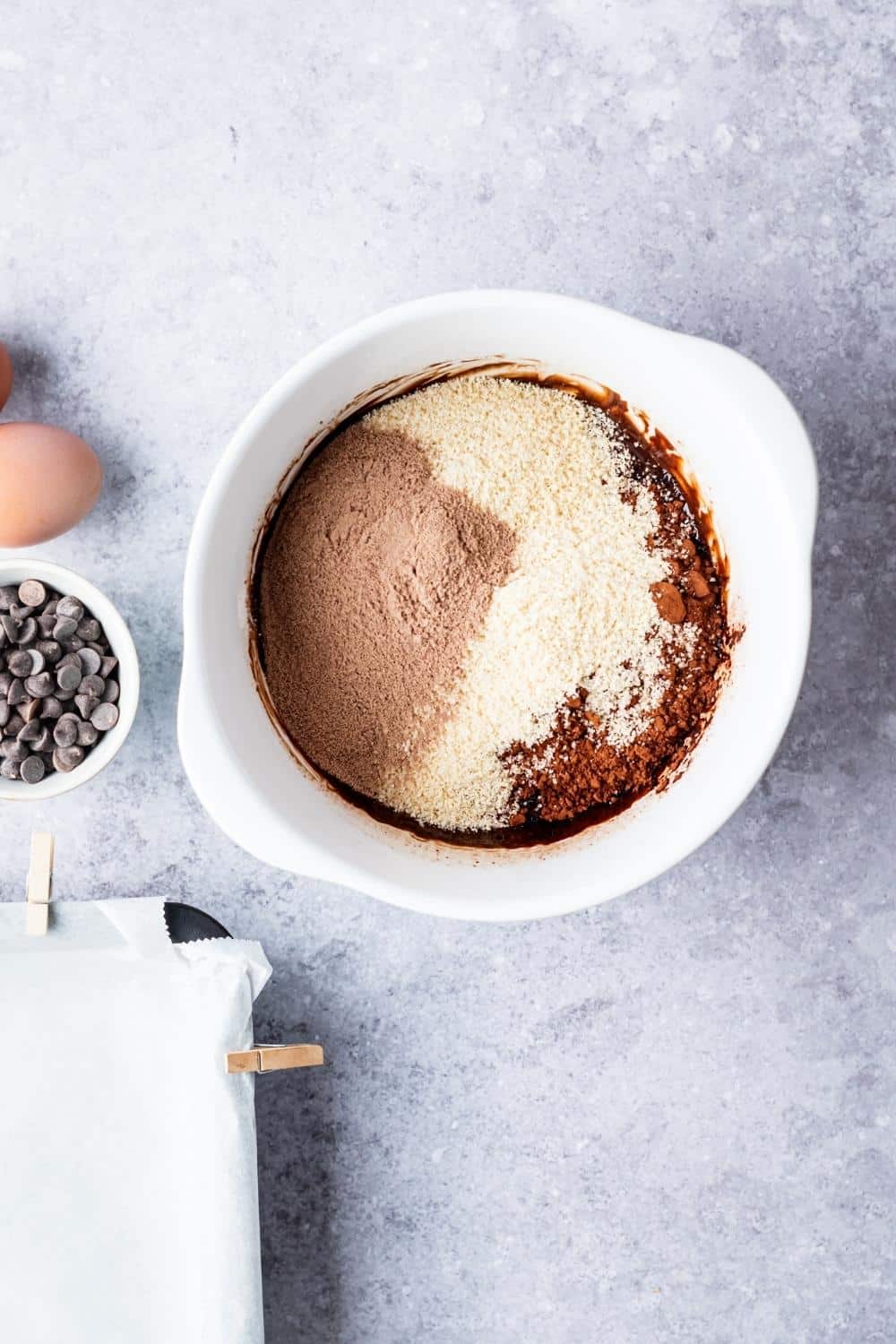 A bowl of cocoa powder, almond flour, chocolate protein powder in a bowl.