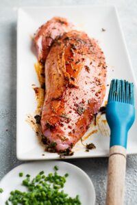 Marianted turkey tenderloin on a white plate.