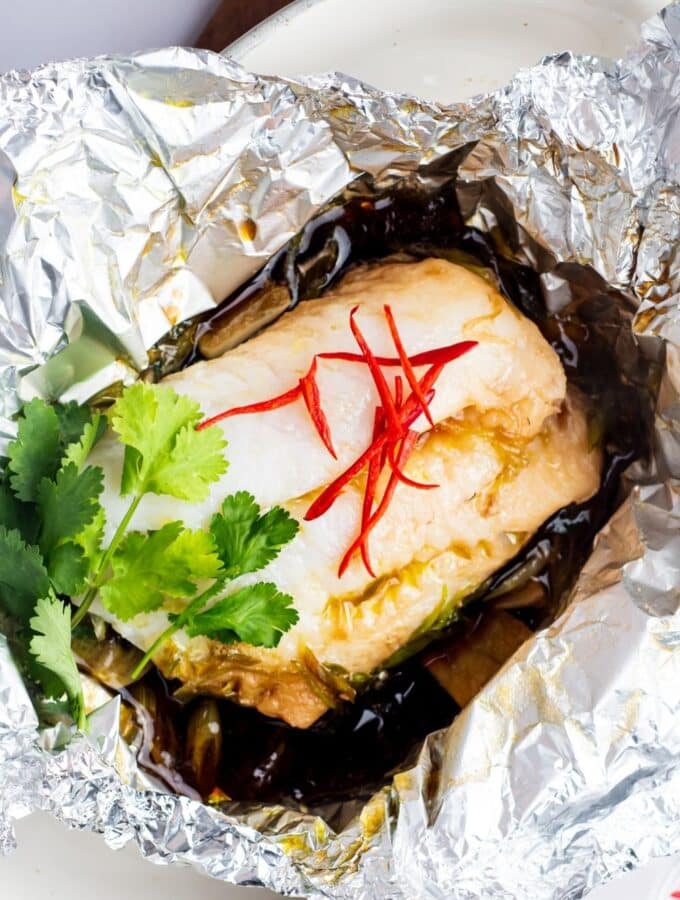 A whole cooked sea bream fillet in a tin foil basket.