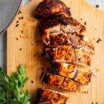 Turkey tenderloin sliced into pieces on a wooden cutting board.