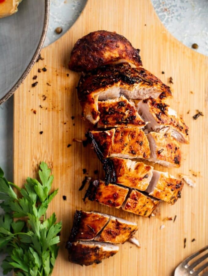 Turkey tenderloin sliced into pieces on a wooden cutting board.