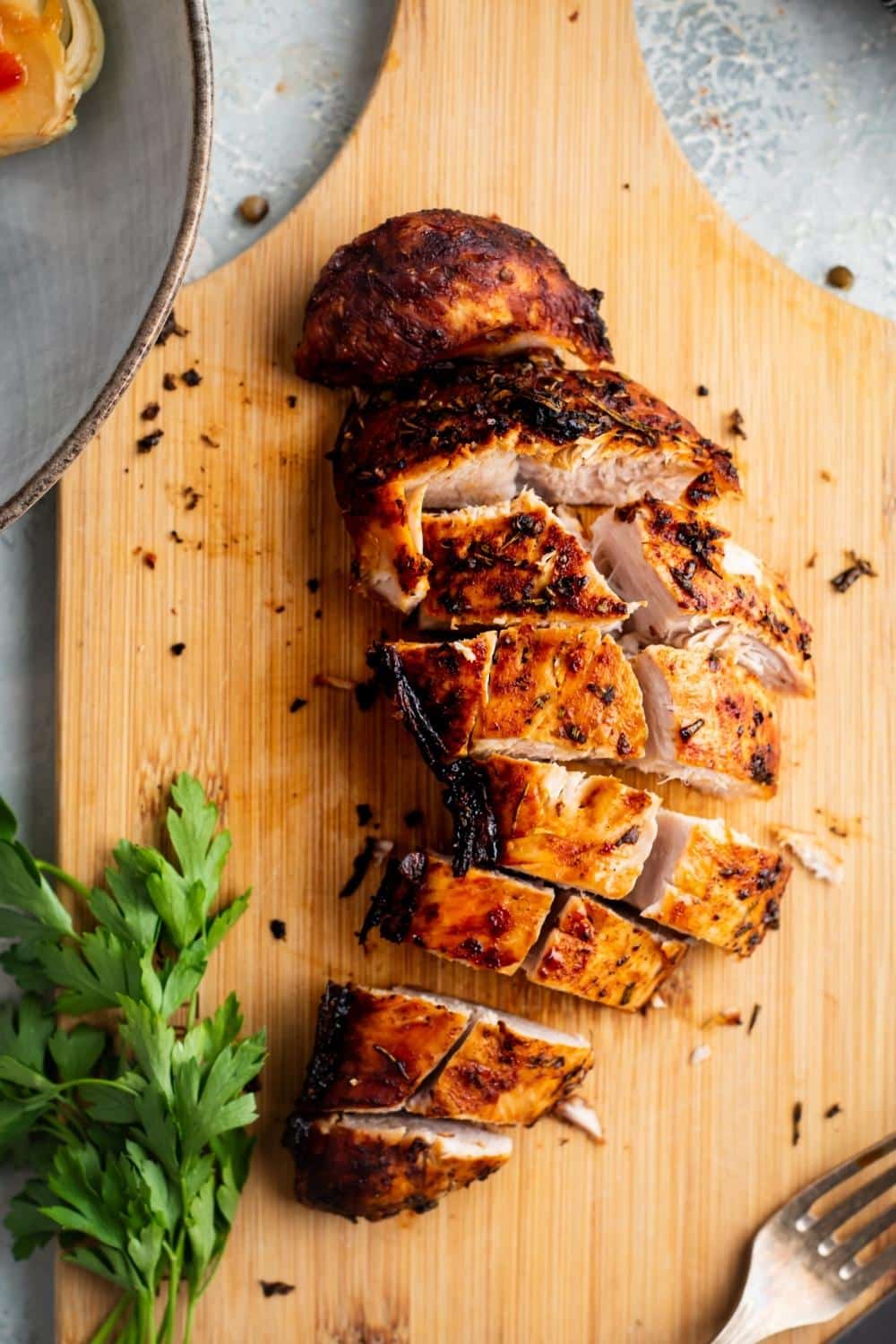 Turkey tenderloin sliced into pieces on a wooden cutting board.