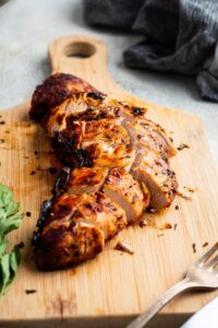 Turkey tenderloin sliced on a wooden cutting board.