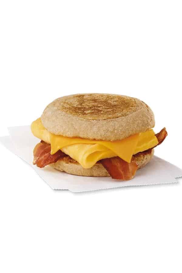 A sliced english muffin with bacon, egg, and cheese between it.
