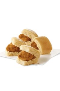 Four mini biscuits with a chicken nugget between them.
