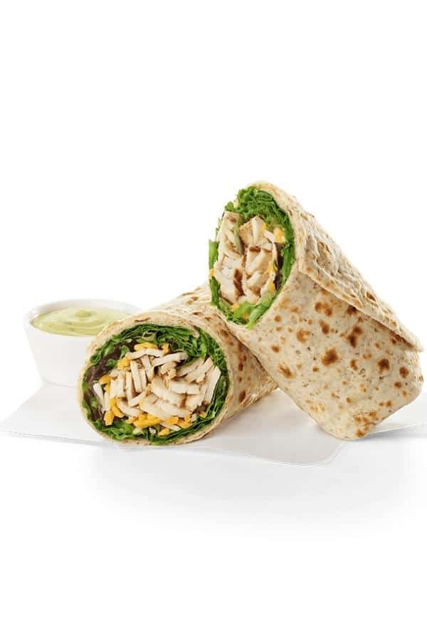 A chick fil a chicken cool wrap cut in half consisting of lettuce, chicken, and shredded cheese in a wrap.