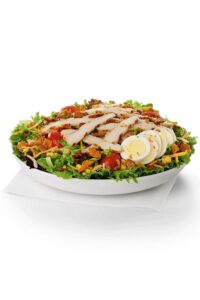 A chick fil a cobb salad in a white bowl.