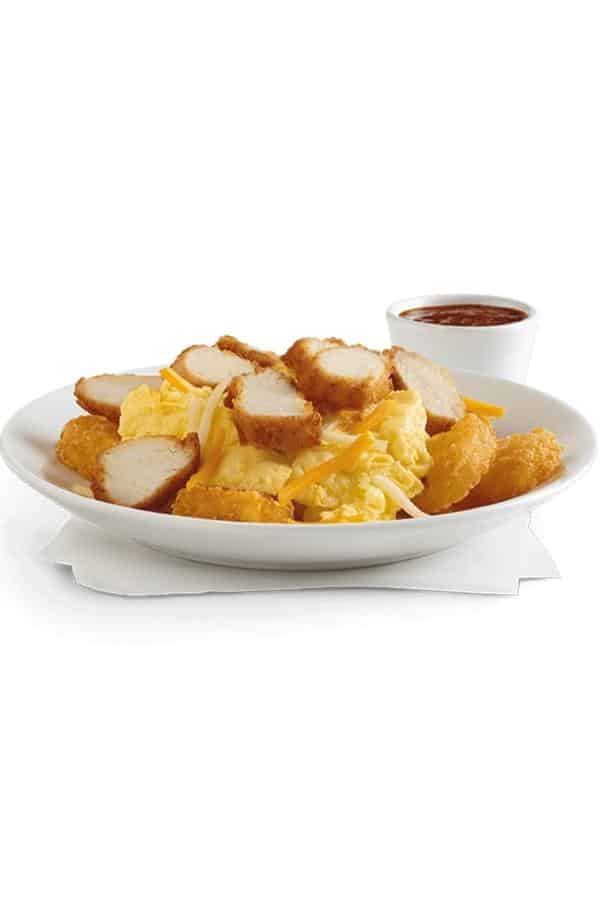 A white plate with scrambled eggs, hash browns, and sliced chicken strips on it.