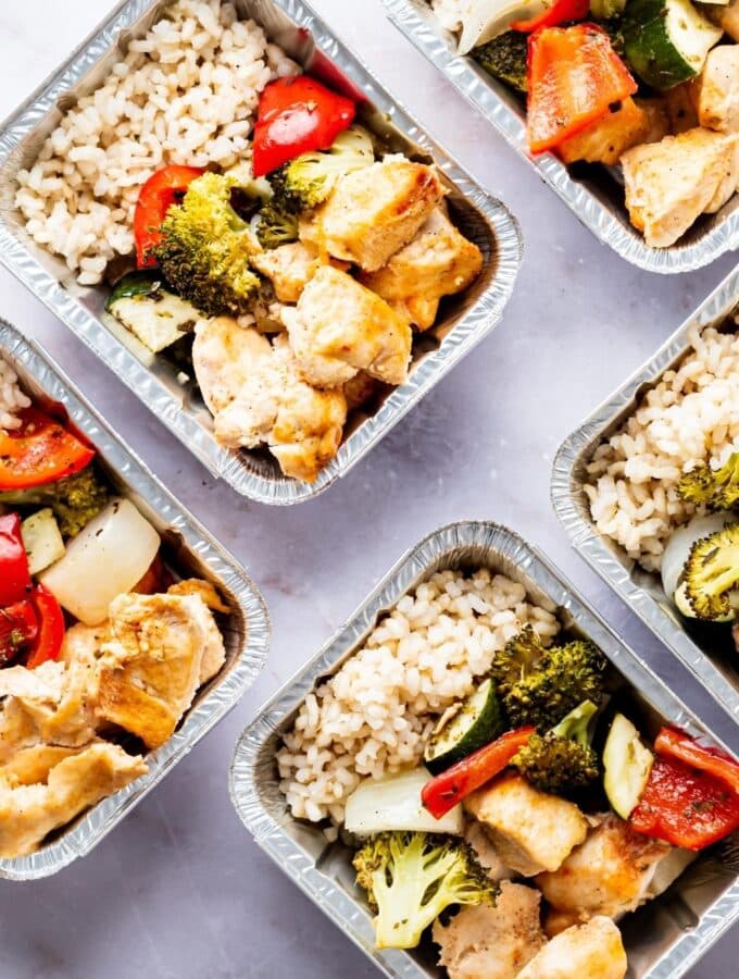 A few containers filled with chicken, rice, and veggies.