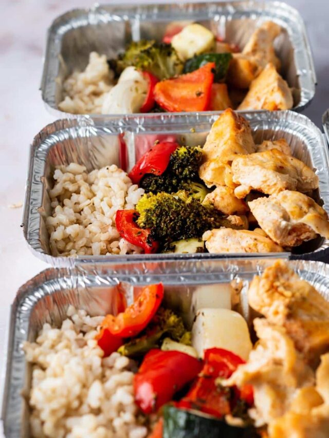 Three individual containers with rice, veggies, and chicken in it.