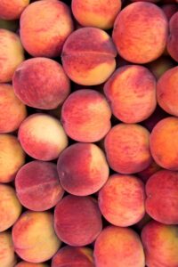 A bunch of peaches in a pile.